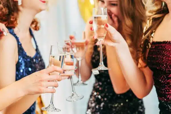 women in fancy cocktail attire with champagne glasses